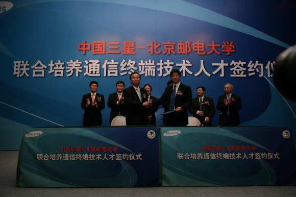 중국삼성 휴대전화 부문장 노기학(왼쪽) 전무와 베이징요우뎬 대학 장잉하이(張英海) 부총장이 29일 베이징 쿤룬호텔에서 협약서를 교환하며 악수하고 있다.  중국삼성 제공