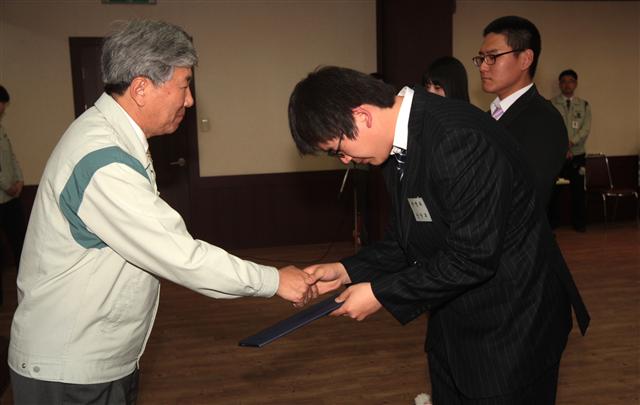 이인정(왼쪽) 태인 대표이사가 회사 강당에서 충북지역 대학 산악부와 체육 꿈나무들에게 장학금을 전달하고 있다.