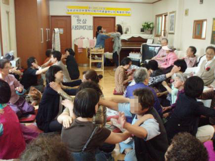 8일 경기 평택 ‘햇살복지회’에서 위안부 피해자 할머니와 기지촌 할머니간 특별한 만남이 있었다. 기지촌 여성들과 함께하는 여성연대가 어버이날을 맞아 마련한 행사로 회원과 할머니들이 서로의 어깨 위에 손을 올린 채 율동을 배우고 있다. 여성연대 제공 