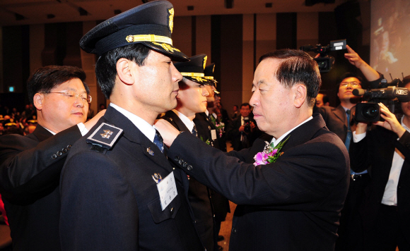 13일 오전 서울 중구 태평로 한국프레스센터에서 열린 제27회 교정대상 시상식에서 김경한(오른쪽) 법무부장관이 대상 수상으로 1계급 특별 승진한 김윤곤 부산구치소 교위에게 새 계급장을 달아주고 있다. 손형준기자 boltagoo@seoul.co.kr