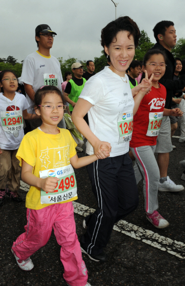 엄마와… 엄마가 두 딸의 손을 잡고 밝은 표정으로 서울 상암동 월드컵경기장 주변 도로를 달리고 있다.  