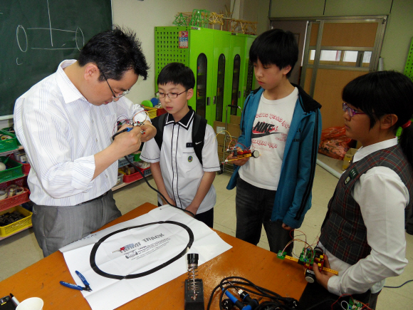 18일 서울시 성북구 돈암초등학교 방과후 발명교실에서 학생들이 지도교사의 실험을 호기심 어린 눈으로 지켜보고 있다. 발명교실은 실험과 놀이를 통해 학생 스스로 답을 찾게 하는 열린 수업이다. 돈암초등학교 제공