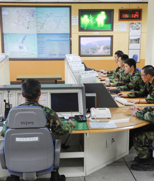 육군 과학화전투훈련단의 훈련통제본부(EXCON) 통제관들이 전투 현장을 확인하고 있다. 전면 대형 스크린에는 훈련부대 병사들의 이동 경로와 교전 상황이 실시간으로 나타난다.  인제 안주영기자 jya@seoul.co.kr 
