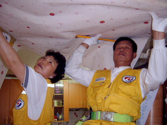 지난 4일 인천의 한 소년가장의 집을 찾은 변경달· 강효숙씨 부부가 도배 봉사를 하고 있다. 