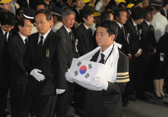 29일 오후 8시30분쯤 수원 연화장에서 화장을 마친 노무현 전 대통령의 유골함을 아들 건호씨가 든 채 운구차에 타기 위해 걸어가고 있다. 운구차는 자정이 넘어 봉하마을에 도착했다.  사진공동취재단