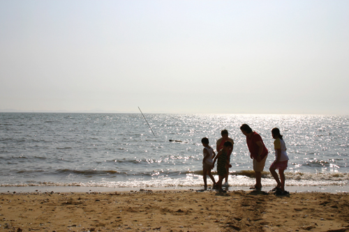 해변을 걷는 가족이 평화롭다