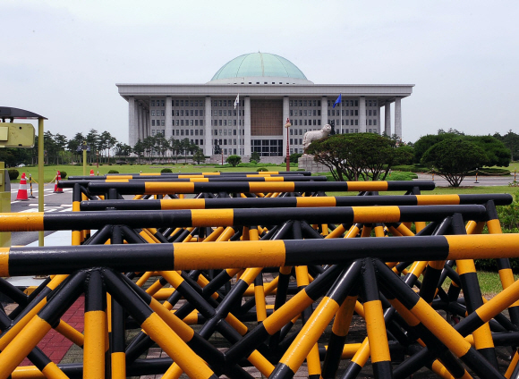 꽉 막힌 국회  여야의 지루한 정쟁으로 6월 임시국회는 아직도 일정이 잡히지 않았다. 21일 여의도 국회의사당 앞에 있는 바리케이드가 현재의 답답한 정치상황을 보여주는 듯하다. 이호정기자 hojeong@seoul.co.kr