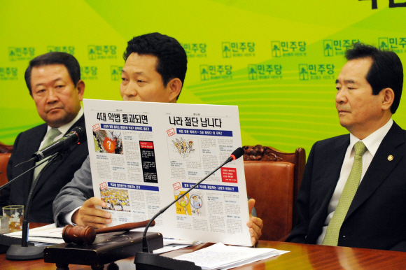 민주당 송영길(가운데) 최고위원이 24일 국회에서 열린 최고위원회의에서 참여정부 당시인 5년 전 국가보안법과 사립학교법 등 개혁법안을 ‘4대 악법’이라고 규정한 한나라당 당보를 들어보이고 있다. 오른쪽은 정세균 대표,  이호정기자 hojeong@seoul.co.kr