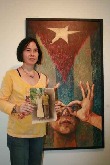 외할아버지 박두현·외할머니 김선희씨의 흑백사진을 들고 작품 앞에 선 알리시아 데 라 캄파 팍. 