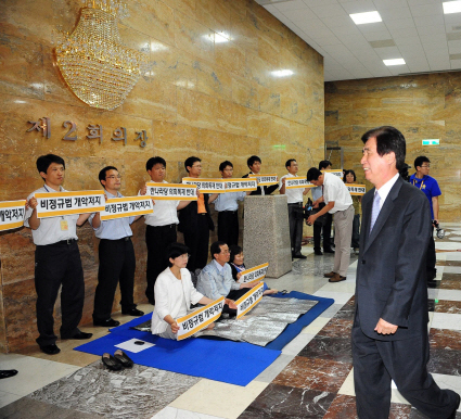 野 국회시위  26일 한나라당 의원총회가 열린 국회 예결위회의장 앞에서 민주노동당 소속 의원 등이 ‘비정규직법 개악 저지’를 주장하며 시위하는 가운데 고흥길(오른쪽) 의원이 회의장으로 들어가고 있다. 이호정기자 hojeong@seoul.co.kr