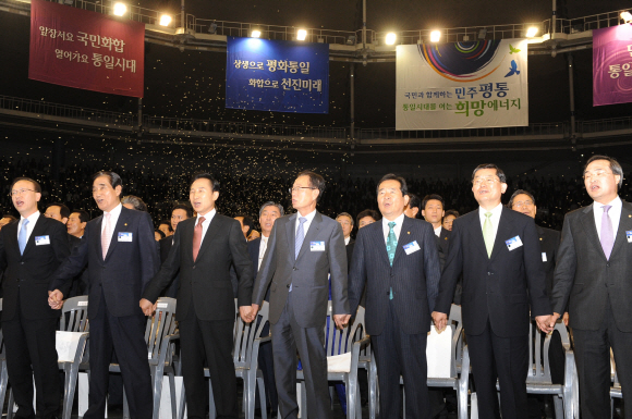 이명박(앞줄 왼쪽에서 세번째) 대통령이 1일 서울 올림픽공원 체조경기장에서 열린 제14기 민주평화통일자문회의(민주평통) 출범회의에서 다른 참석자들과 함께 ‘우리의 소원’을 부르고 있다. 앞줄 왼쪽부터 현인택 통일부 장관, 이기택 민주평통 수석부의장, 이 대통령, 한나라당 박희태 대표, 민주당 정세균 대표, 창조한국당 문국현 대표, 김대식 민주평통 사무처장. 최해국기자 seaworld@seoul.co.kr 