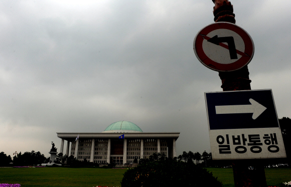 2일 국회내 의사당과 ‘일방통행’ 표지판 위로 먹구름이 잔뜩 끼어 있다. 무능과 무책임으로 비정규직 해법을 찾지 못하고 있는 국회의 답답한 현실을 보여주는 듯하다. 이호정기자 hojeong@seoul.co.kr