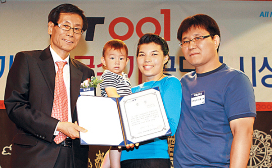 3일 서울 광화문 KT아트홀에서 KT가 주관하는 다문화가정 한글수기 공모전에서 국제LOVE상(최우수상)을 받은 마하노바 아셀(오른쪽 두번째·29·카자흐스탄) 가족과 KT국제전화국 황완묵(왼쪽) 국장이 포즈를 취하고 있다. KT 제공