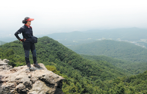 경기 수원의 광교산은 임진왜란, 병자호란 등 굴곡의 민족사를 묵묵하게 지켜본 산이다. 이제는 도시민들에게 넉넉한 품을 내줘 휴식처 역할을 톡톡히 하고 있다.  한 등산객이 형제봉 정상에서 멀리 내다보이는 수원시내를 바라보고 있다. 도준석기자 pado@seoul.co.kr