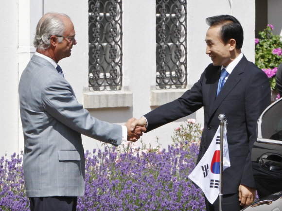 스웨덴을 방문 중인 이명박(오른쪽) 대통령이 12일 스웨덴 동남부 웰란 시에 있는 국왕의 여름 별장인 솔리덴 궁전에서 칼 구스타프 16세 국왕과 악수하고 있다. 이 대통령과 부인 김윤옥 여사는 구스타프 국왕 내외와 오찬을 함께 했다. 웰란(스웨덴) 최해국특파원 seaworld@seoul.co.kr