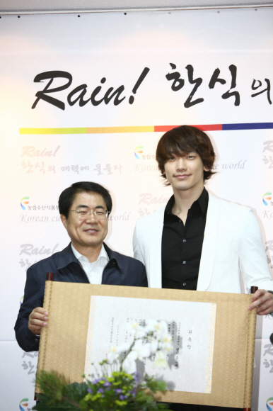 13일 장태평(왼쪽) 농식품부 장관과 비가 한지 두루마리로 만들어진 홍보대사 위촉장을 들고 포즈를 취하고 있다. 농식품부 제공