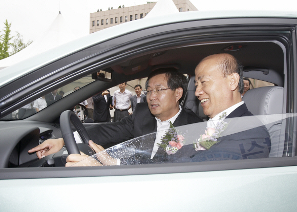 13일 과천정부청사에서 이만의(오른쪽) 환경부장관이 양웅철 현대차 사장으로부터 아반떼 하이브리드 1호 출시 차량을 전달받은 뒤 시승해 보고 있다.  환경부 제공