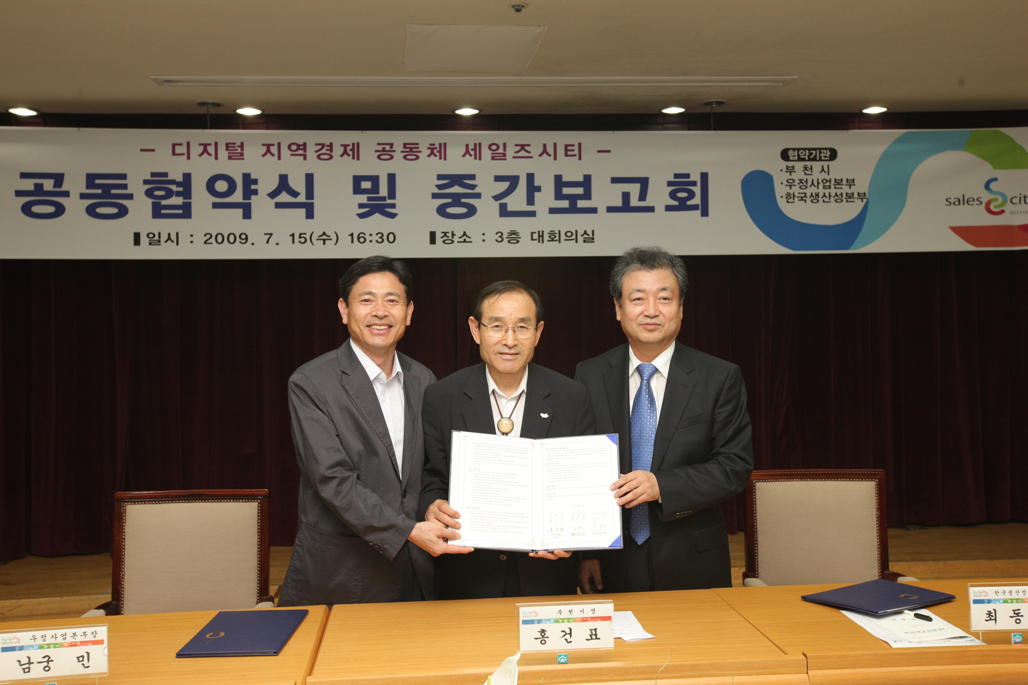 남궁민(왼쪽) 우정사업본부장과 홍건표(가운데) 부천시장, 최동규 한국생산성본부 회장이 부천시청에서 ‘세일즈 시티’ 공동 계약식을 가졌다.  우정사업본부 제공