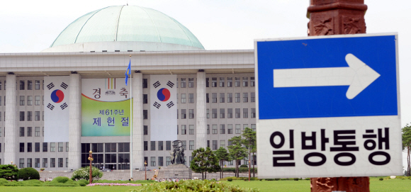 국회가 제 61주년 제헌절을 하루 앞둔 16일에도 여야의 본회의장 동시 점거로, 정상화의 돌파구를 찾지 못한 채 혼란에 빠져 있다. 사진은 제헌절을 경축하는 현수막이 내걸린 국회 본청 주변의 모습. 안주영기자 jya@seoul.co.kr