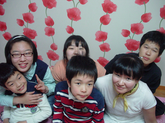 배국현(오른쪽 아래)씨가 한집에 사는 장애아 5남매와 함께 다정하게 모여 앉았다. 
