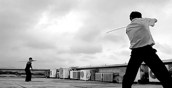 대역이나 와이어 없이 검술액션을 펼쳐보이는 도시무협영화 ‘도시락’의 한 장면. 결투를 벌이고 있는 두 등장인물이 누군지는 영화관에서 직접 확인해야 한다.  청년필름 제공