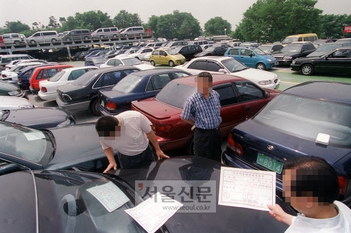 서울 지역의 한 중고차 매매단지를 찾은 구매자들이 차량을 구입하기에 앞서 매물로 나와있는 차를 들여다보며 상태를 점검하고 있다.  손형준기자 boltagoo@seoul.co.kr