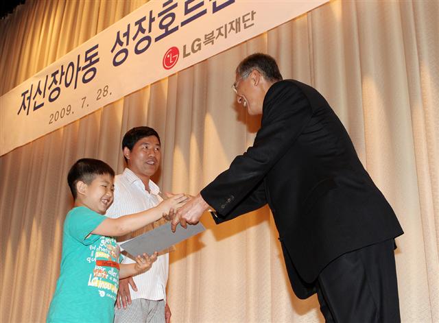 강유식 (주)LG 부회장이 ‘저신장 아동 성장호르몬제 기증식’에서 한 어린이에게 기증서를 전달하고 있다. LG그룹 제공