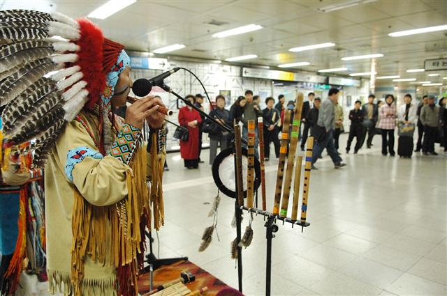출근 인파로 붐비는 서울시의 한 지하철역에서 인디언 복장 차림의 한 공연자가 전통악기를 연주하고 있다. 서울메트로는 지하철역에서 현악4중주, 포크송 공연 등 다양한 문화예술 행사를 펼치고 있다.  서울메트로 제공