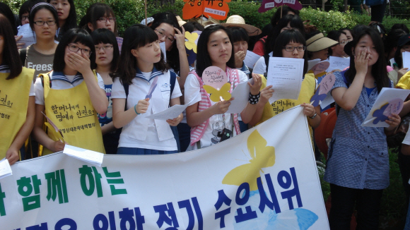 29일 서울 중학동 주한일본대사관 앞에서 열린 ‘제876차 일본군 위안부 문제 해결을 위한 수요집회’에서 아이쿱생협 가정의 아이들이 위안부 피해자 할머니들을 응원하는 편지와 부채를 들고 함께 집회에 참석하고 있다.　