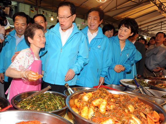 한나라당 박희태(앞줄 왼쪽에서 두번째) 대표가 30일 서울 아현동 재래시장에서 김치가게를 하는 할머니에게 장사가 잘되는지를 묻고 있다. 안주영기자 jya@seoul.co.kr