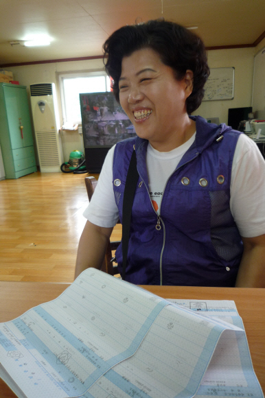 주민 조철순씨가 4일 개포4동 주민자치센터에 전입신고를 마친 뒤 발급받은 주민등록등본을 보여 주며 환하게 웃고 있다.