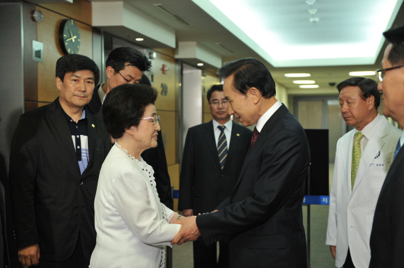 이명박 대통령이 11일 김대중(DJ) 전 대통령의 병문안을 위해 서울 신촌세브란스병원을 찾아 이희호 여사의 손을 잡고 위로하고 있다. 최해국기자 seaworld@seoul.co.kr
