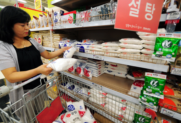 국제 원당가격 상승으로 국내 제당업계가 설탕가격 인상을 추진 중인 가운데 12일 서울의 대형할인마트를 찾은 한 고객이 설탕코너에서 제조회사가 다른 설탕 포대를 들고 설탕가격을 꼼꼼히 비교하고 있다.  안주영기자 jya@seoul.co.kr