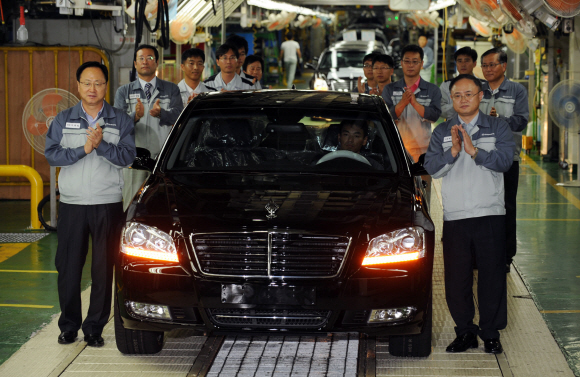 첫 생산차 ‘체어맨W’  13일 쌍용자동차 평택공장에서 이유일(왼쪽)·박영태(오른쪽) 공동 관리인과 직원들이 조업을 재개한 뒤 처음으로 생산된 체어맨W 출고를 기념하며 박수를 치고 있다. 도준석기자 pado@seoul.co.kr