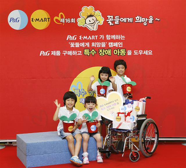 이마트와 P&G가 공동으로 펼치는 특수아동 돕기 캠페인에서 어린이들이 새싹이 담긴 화분을 안은채 손을 흔들고 있다.  이마트 제공 