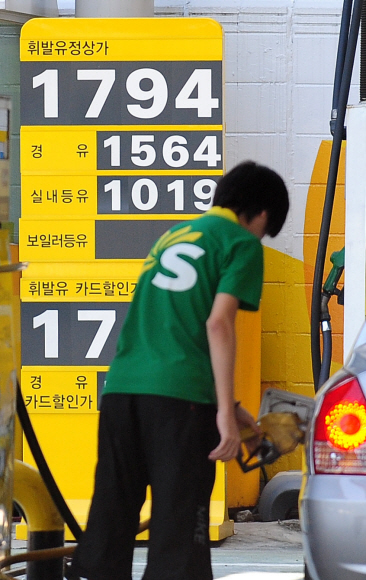 정부가 기름값 인하를 염두에 두고 실시한 정유사별 가격공개 정책이 100일을 맞았지만 당초 의도한 효과를 얻지 못했다는 평가를 받고 있는 가운데 서울의 주유소에서 주유원이 휘발유를 넣고 있다. 손형준기자 boltagoo@seoul.co.kr