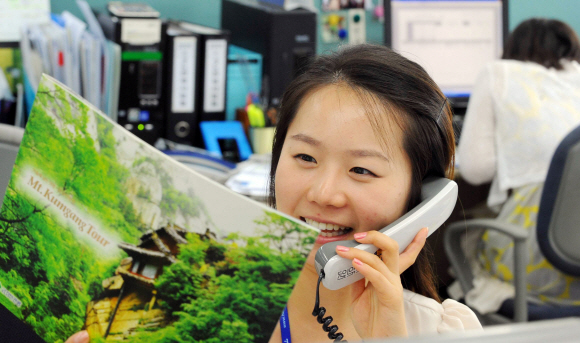 밝아진 현대  현정은 현대그룹 회장이 북한과 금강산 관광 재개 등을 합의하고 돌아온 17일 서울 계동 현대아산 관광경협본부의 한 직원이 밝은 표정으로 금강산 관광 문의전화를 받고 있다. 김명국기자 daunso@seoul.co.kr