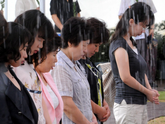 비가 와도…  비가 오락가락한 20일 서울시청 앞 서울광장에 마련된 고 김대중 전 대통령의 분향소를 찾은 시민들이 고인의 영정 앞에 고개 숙여 추모하고 있다. 이언탁기자 utl@seoul.co.kr