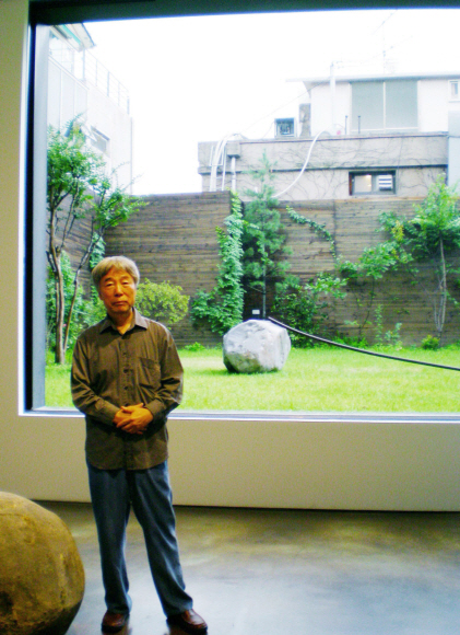 이우환 작가 뒤편으로 보이는 것이 이번에 전시되는 작품. 자연석은 수석처럼 요란하지 않고 둥글고 자기주장이 강하지 않은 것을 골랐지만, 단단하고 강인한 한국인들과 닮은 느낌이라고.