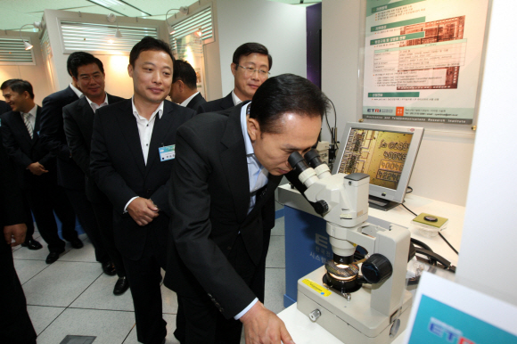 이명박 대통령이 2일 서울 상암동 디지털미디어센터에서 열린 ‘IT 코리아 미래전략’ 보고회를 마친 뒤 한국전자통신연구원 시스템반도체 진흥센터를 찾아 현미경으로 반도체 제품을 살펴보고 있다. 최해국기자 seaworld@seoul.co.kr