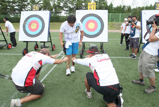 절 받으세요 4일 울산 문수국제양궁장에서 열린 세계선수권 리커브 남자90m 예선에서 오진혁(가운데)이 세계신기록을 세우자 캐나다 선수 라이언(왼쪽)과 듀에니어스가 큰절을 올리고 있다. 울산 연합뉴스