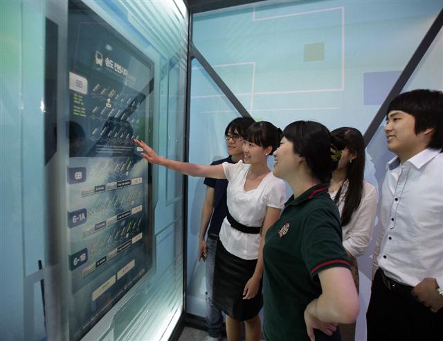 미래 U시티를 체험할 수 있는 인천 송도 SK텔레콤 투머로우시티에서 관람객들이 노선과 도착시간은 물론 빈 좌석수도 알 수 있는 첨단 버스안내 서비스를 보고 있다.  SK텔레콤 제공