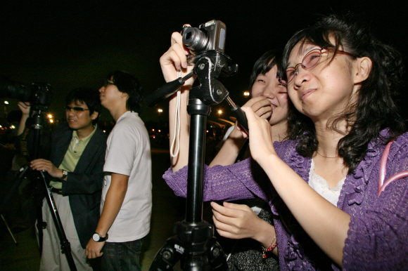 12일 저녁 반포한강공원에서 시각장애인 사진가 모임 ‘마음으로 보는 세상’ 회원들이 상명대학교 영상학부 학생들의 도움을 받아 한강의 야경을 촬영하고 있다.  상명대 제공