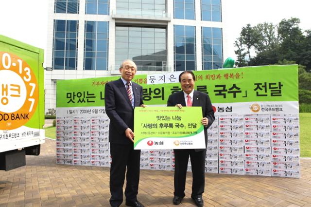 손욱(왼쪽) 농심회장이 17일 본사에서 김득린 한국사회복지협의회장에게 후루룩국수 2000박스를 전달하고 있다.  농심 제공 