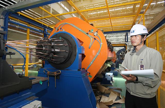 LS전선 동해공장에서 한 직원이 해저케이블을 만들기 위한 과정인 여러 가닥의 구리선을 꼬아 원형의 도체로 만드는 첫 번째 연선공정을 살펴보고 있다. LS전선 제공