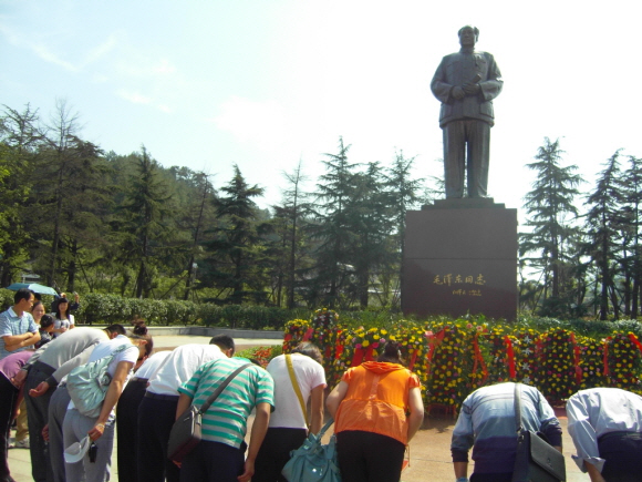 마오쩌둥의 고향인 사오산의 마오 동상 앞에서 중국인들이 헌화한 뒤 예를 표하고 있다.