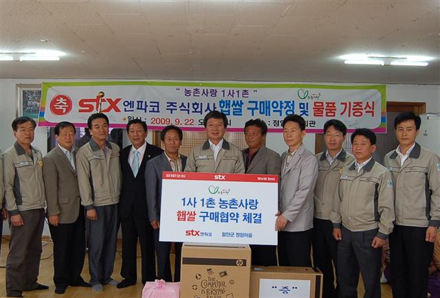 STX엔파코 임직원들이 29일 경남 함안군 정암마을과 ‘1사 1촌 협약’을 체결하고 햅쌀을 전달하고 있다. 