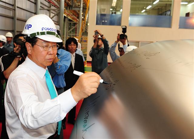 정준양 포스코 회장이 19일 베트남 호찌민 붕타우성 푸미 공단에서 냉연강판 공장 준공식을 마친 뒤 첫 생산된 냉연제품에 “포스코베트남은 포스코와 베트남을 연결해주는 21세기의 상징”이라는 기념 문구를 적고 있다.  포스코 제공