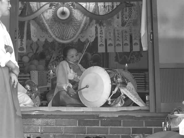 반주를 하던 중 휴대전화를 받는 무당. 최 교수는 “첨단 기술과 기복이 함께하는 현대 사회의 실상을 잘 보여주는 사진”이라고 설명했다. 모시는사람들 제공 