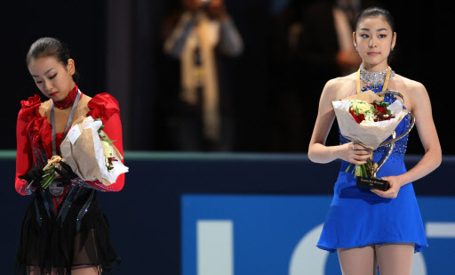 지난 18일 국제빙상경기연맹(ISU) 피겨 그랑프리 1차 대회 여자 싱글에서 2위를 차지한 일본의 아사다 마오(왼쪽)가 압도적인 점수차로 1위에 오른 김연아 옆에서 고개를 떨군 채 시상대에 서 있다. 서울신문 포토라이브러리